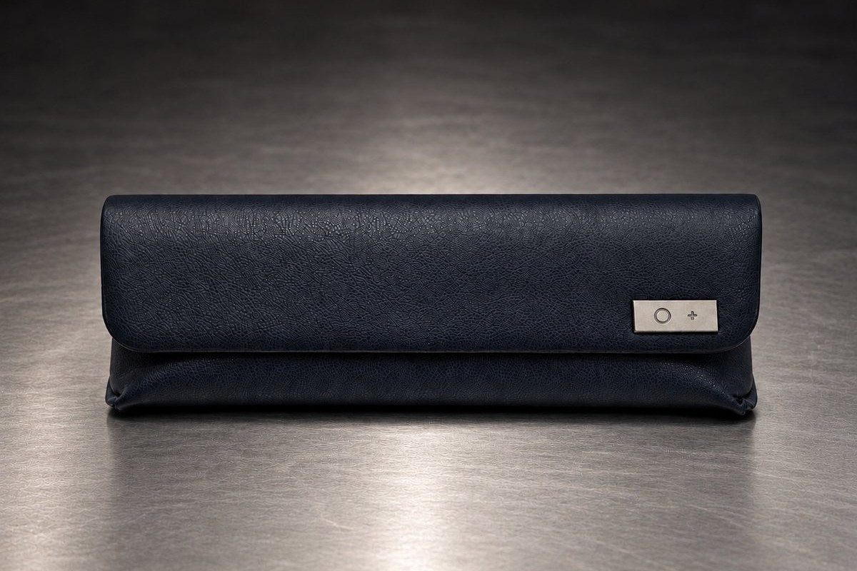 The navy Titanium Core Case, closed, on a brushed-metal surface