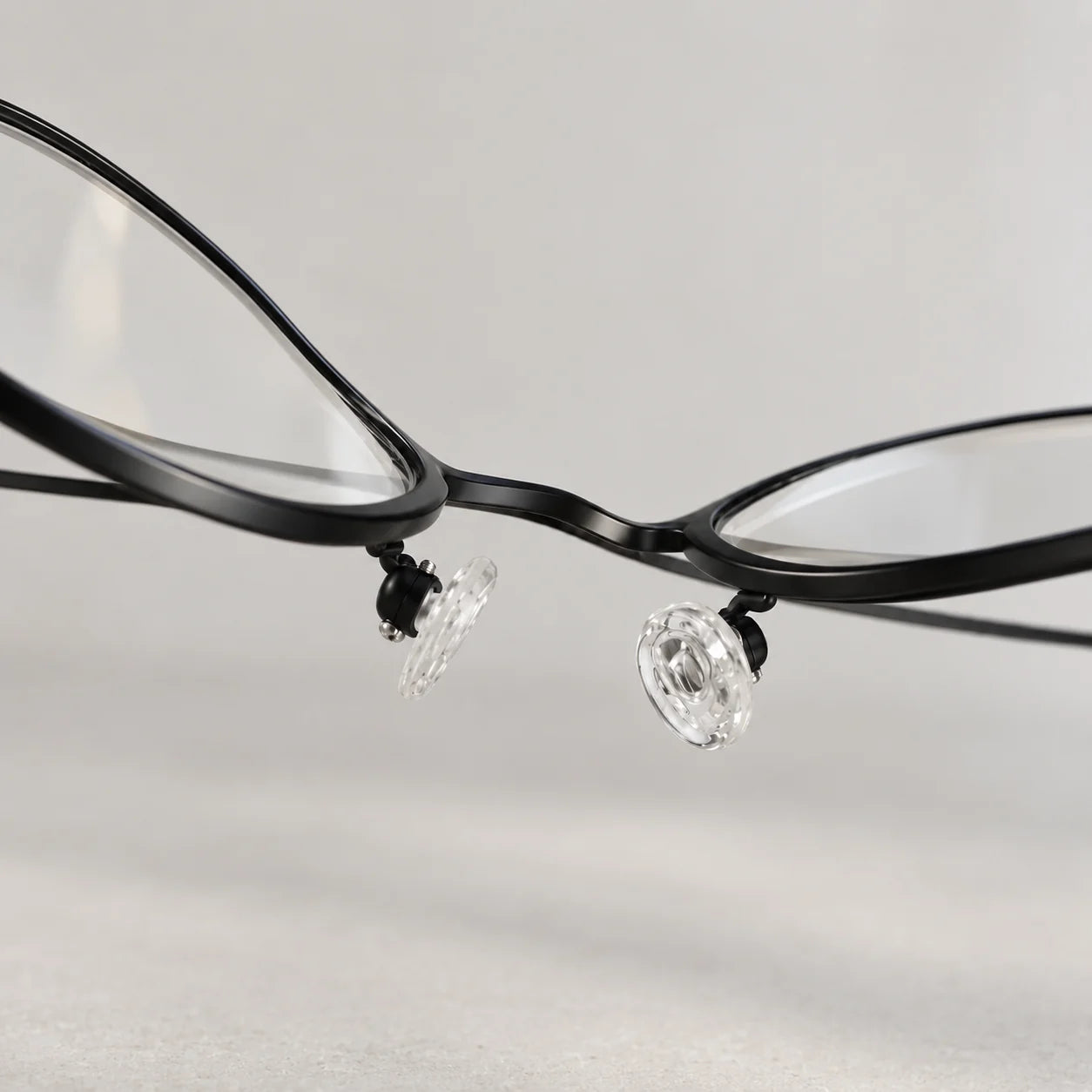 A thin black metal eyeglass frame with its bridge bent out of line.